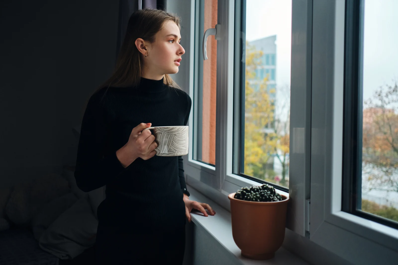 Woman holding a mug by the window – online psychiatry in Hillsboro, OR